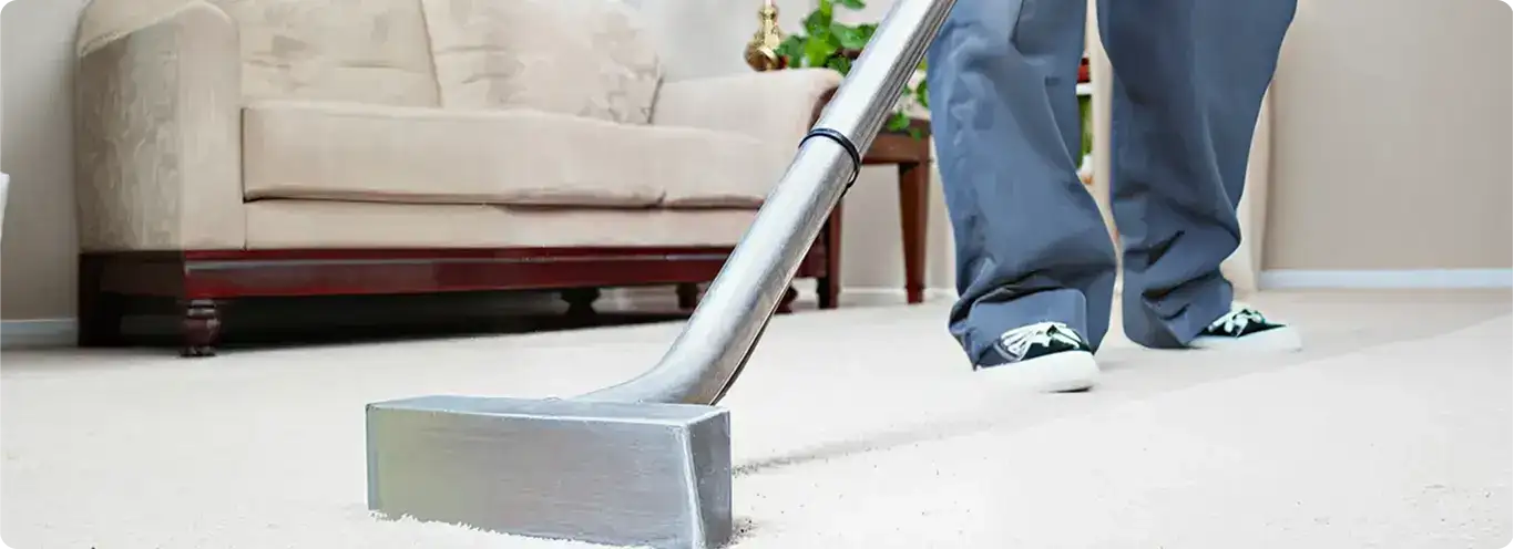 Carpet cleaning technician using a hot-water extraction wand on a light-colored carpet in a living room, Chicago, IL.
